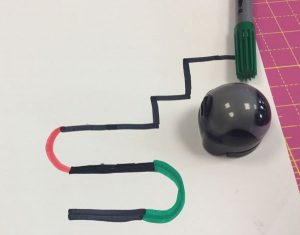 Ozobot steht auf Papier mit farbigen Strichen